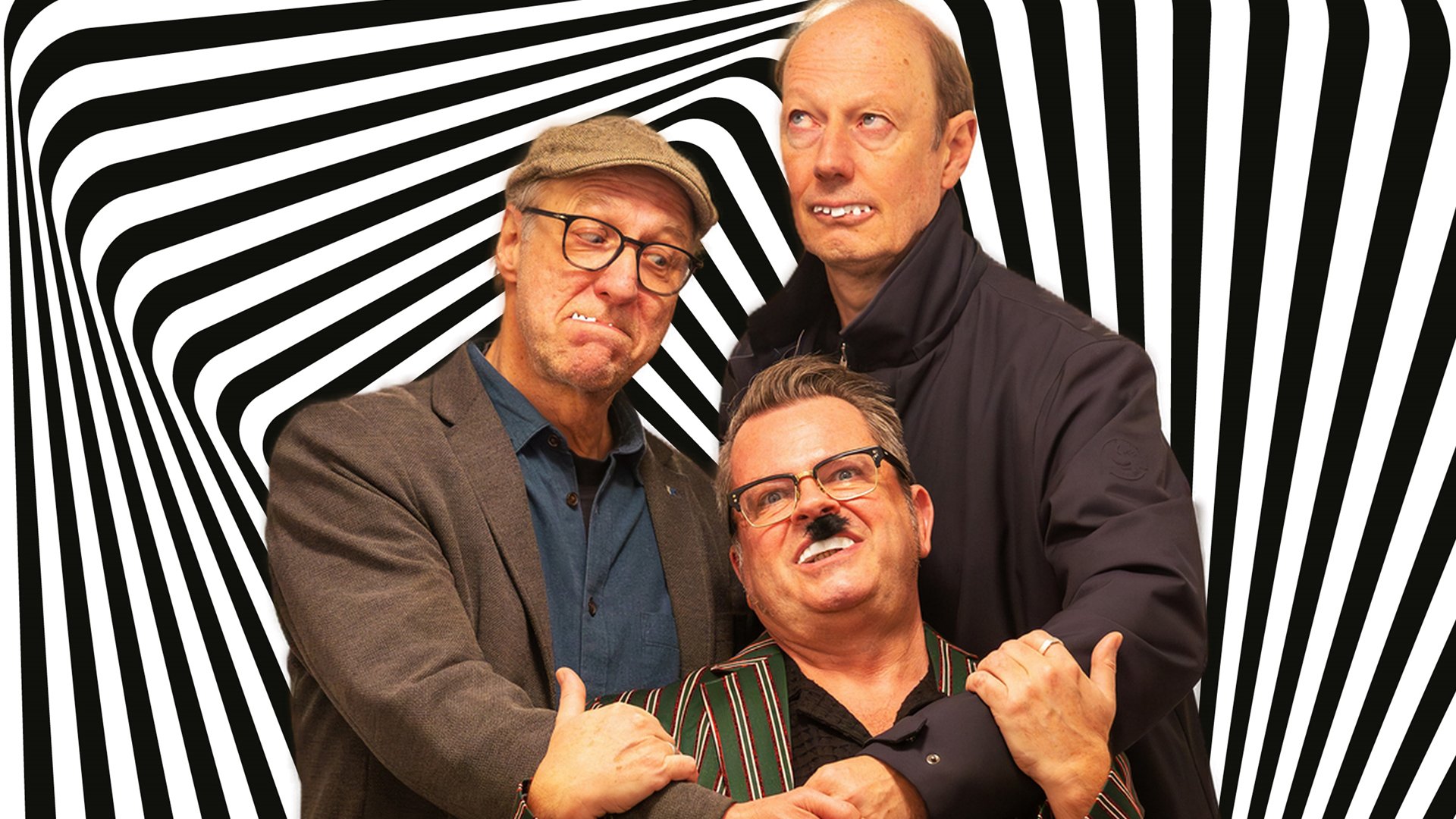 Drei Männer stehen Arm in Arm nebeneinander hinter einem schwarz-weiß gestreiften Hintergrund