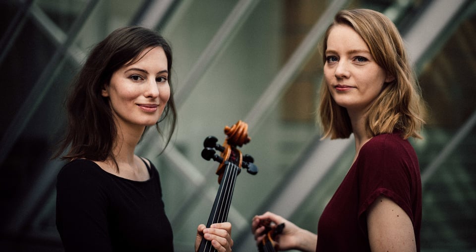 Foto der beiden Künstler*innen mit Instrumenten in den Händen.