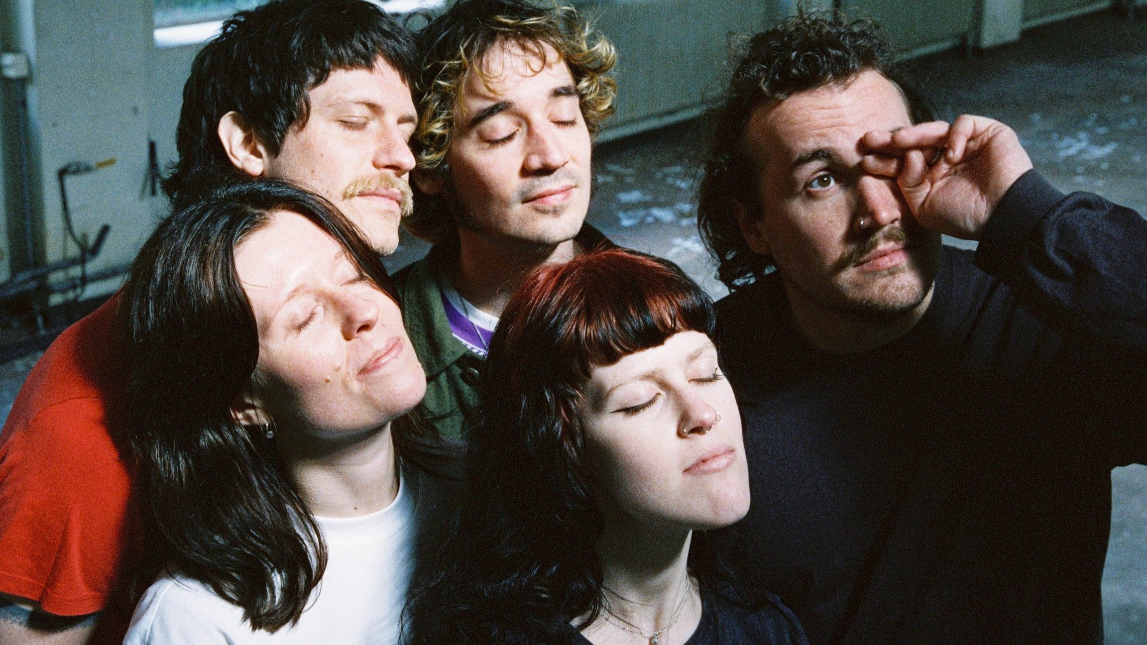 Die fünf Mitglieder der Band Tramhaus stehen zusammen und halten die Köpfe mit geschlössenen Augen nach oben