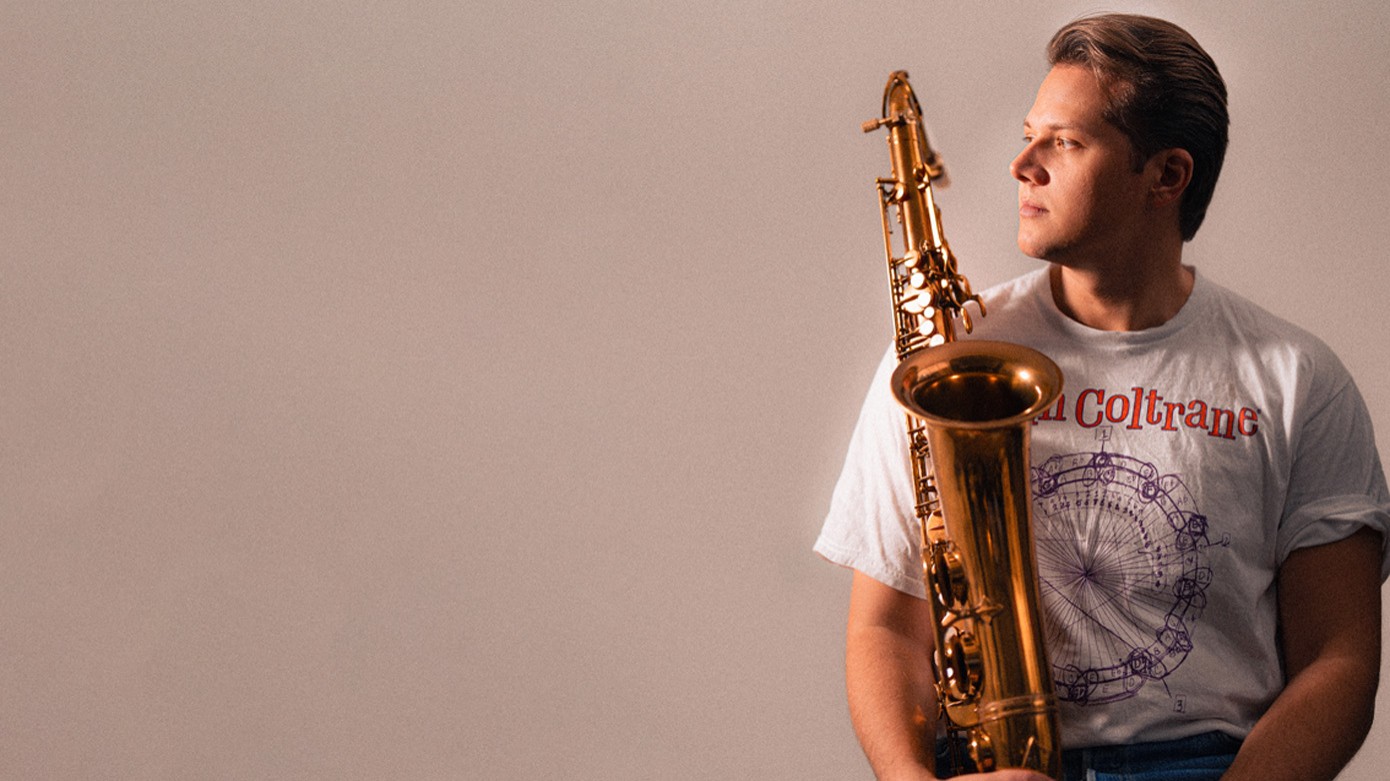 Foto vom Event Armin Jambor Quartet, mit dem Künstler und einem Instrument vor beigem Hintergrund