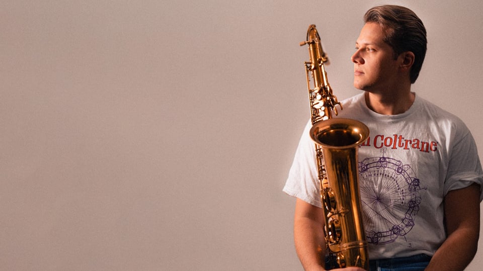 Foto vom Event Armin Jambor Quartet, mit dem Künstler und einem Instrument vor beigem Hintergrund