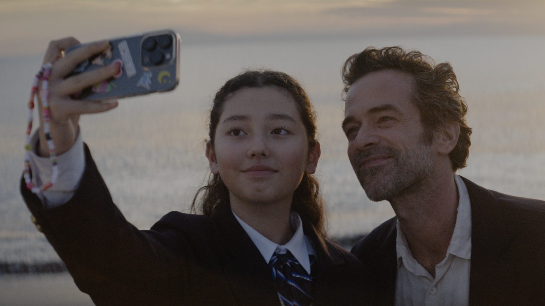 Ein Paar macht ein Selfie, im Hintergrund das Meer