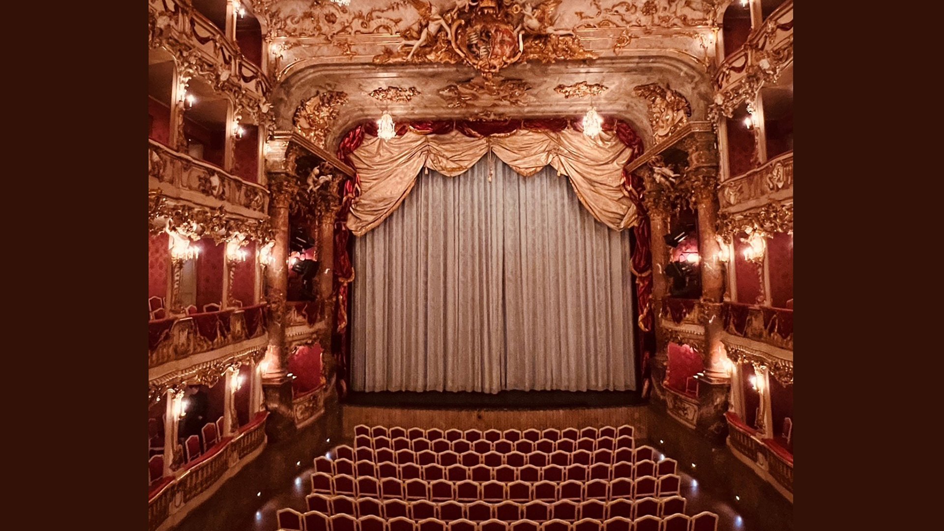EIn Bild der Bühne des Cuvilliés-Theaters mit Logen und Sitzreihen bei geschlossenem Bühnenvorhang