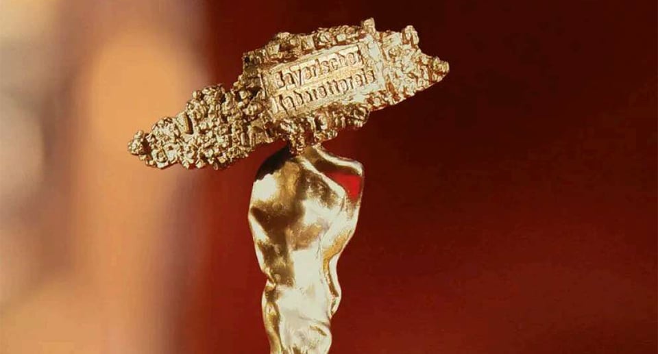 eine goldfarbene Trophäe mit rotem Hintergrund
