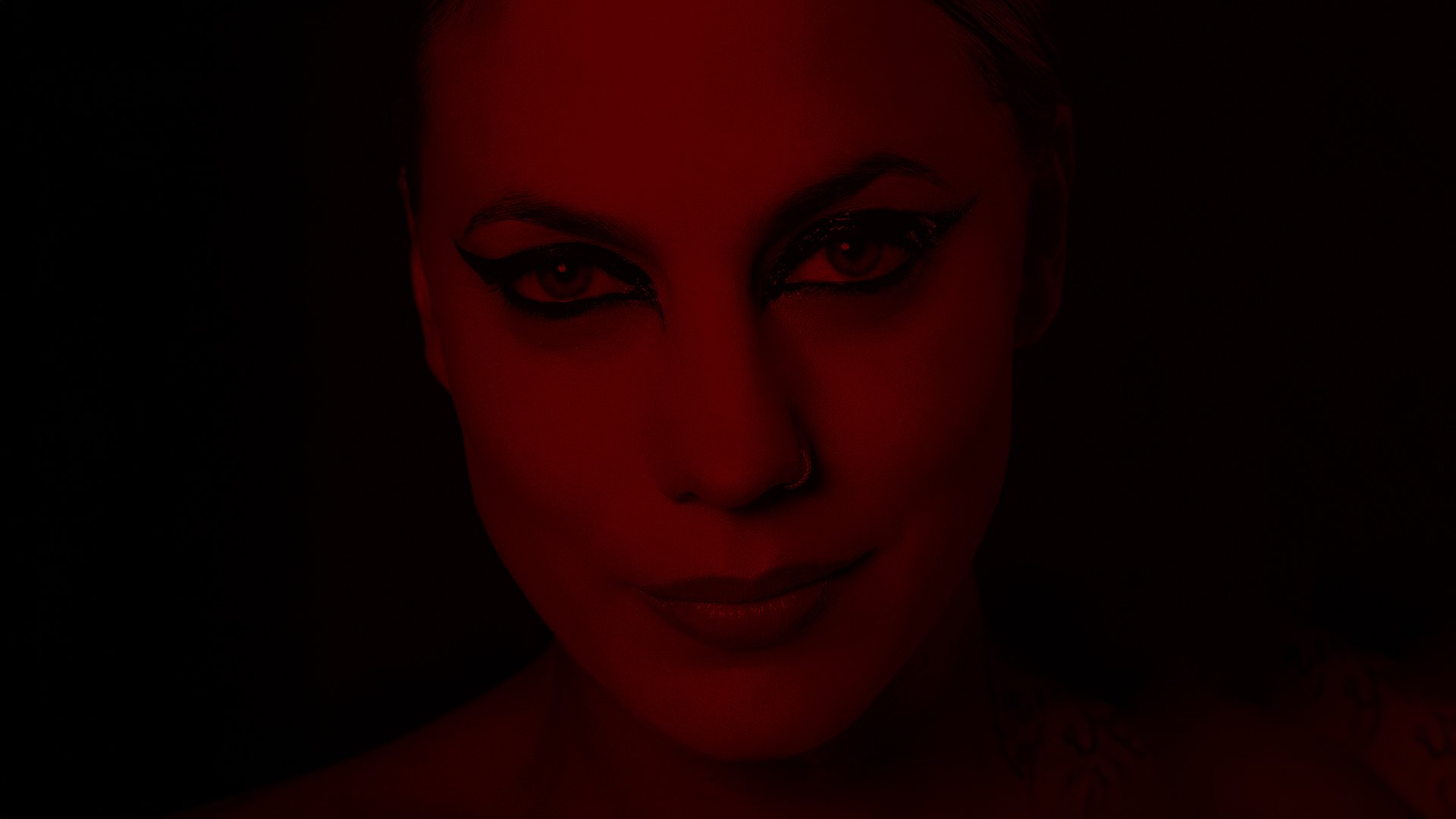 Ein Portrait der Künstlerin Lafee mit stark geschminkten Augen, ihr Gesicht in dunklem rot mit dunklem Hintergrund 