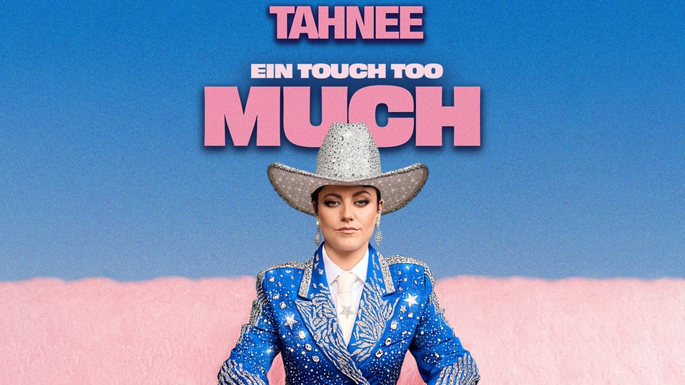 Die Künstlerin Tahnee in glitzerndem blauen Anzug mit silbernen Verzierungen und silbernem Cowboyhut sitzt vor blau‑rosa Hintergrund, darüber der Schriftzug in rosa TAHNEE – EIN TOUCH TOO MUCH
