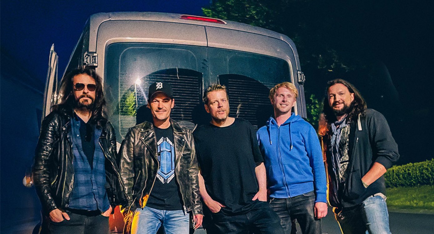 Foto der Gruppe, mit fünf Männern und einem Auto im Hintergrund