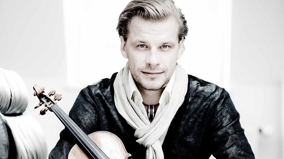 Schwarz-weiß Foto von Kirill Troussov mit Violine, dunkel gekleidet mit hellem Schal vor hellem Hintergrund