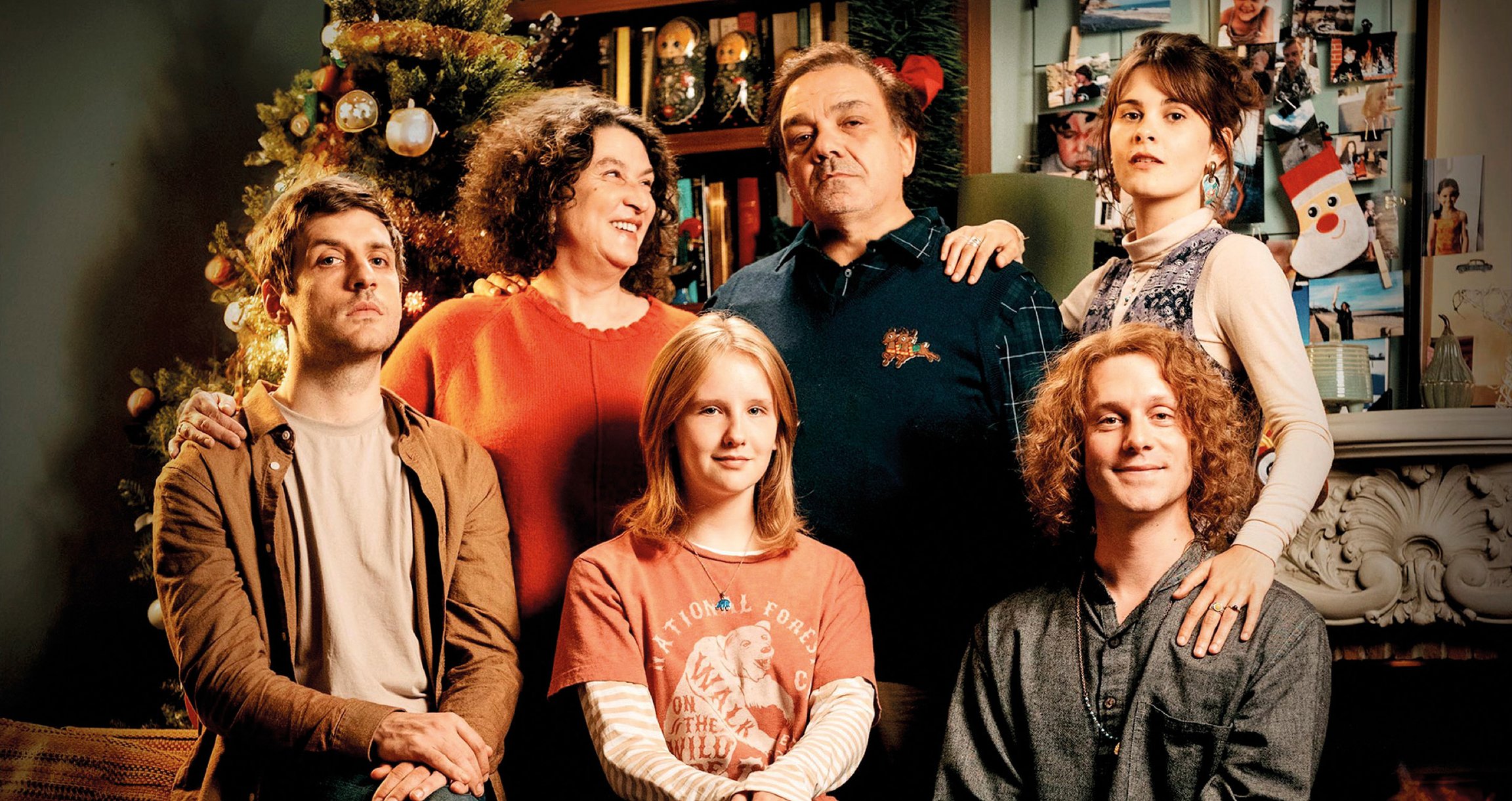 Sechsköpfige Familie in Wohnzimmer vor Weihnachtsbaum 