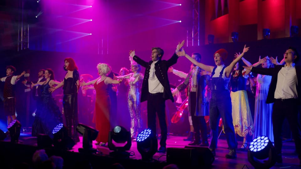 Auf dem Bild sind Menschen auf der Bühne zu sehen.