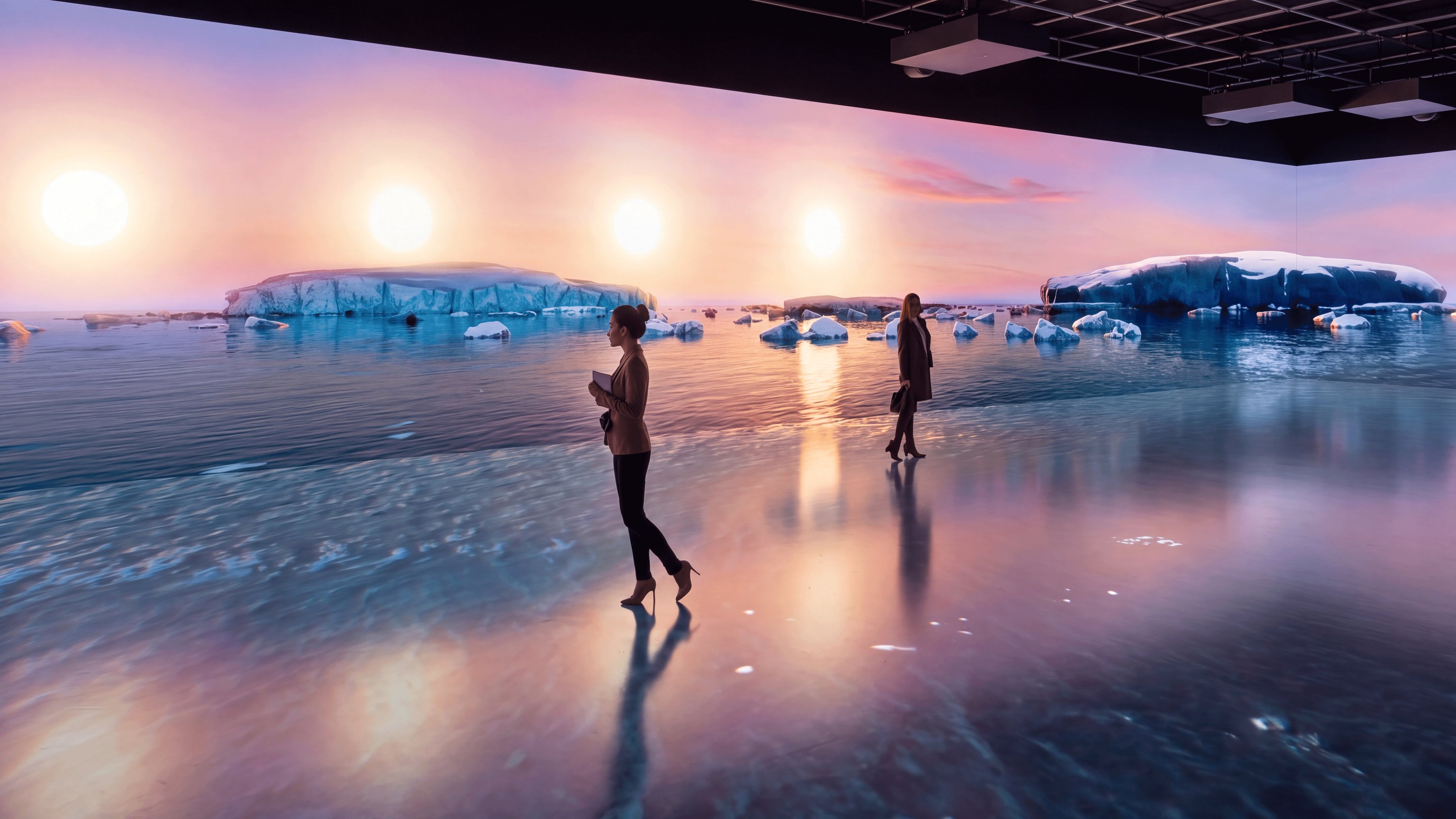 Immersiver Ausstellungsraum der Polarwelten mit raumhohen Projektionen einer arktischen Küstenlandschaft bei tief stehender Sonne, schwimmenden Eisbergen und spiegelnder Wasseroberfläche, während mehrere Besuchende durch den abgedunkelten Raum zwischen den großflächigen Projektionen gehen.