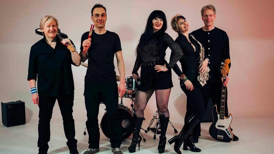 Bild der schwarz gekleidetetn fünfköpfigen Gruppe mit Instrumenten