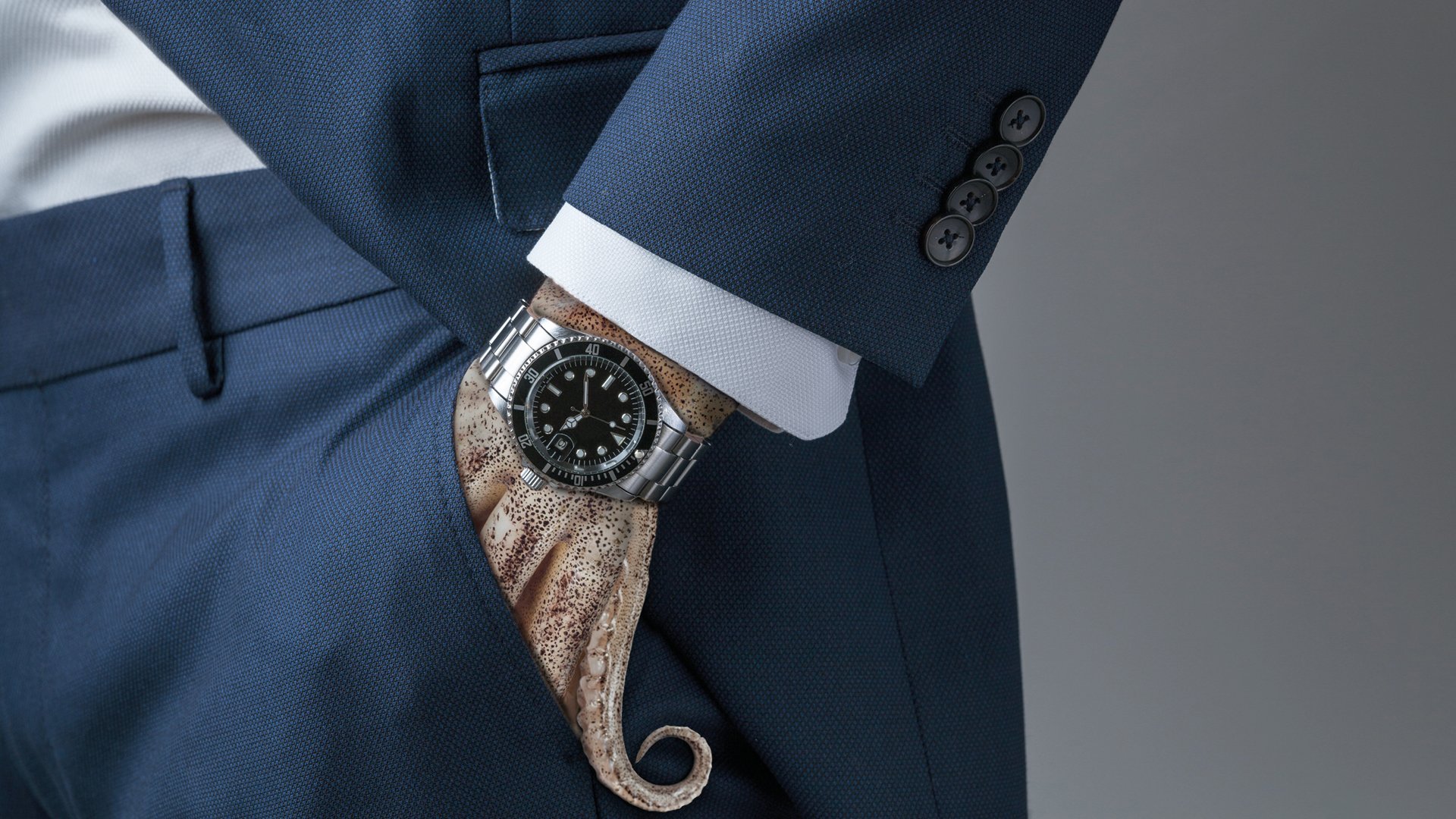 Foto für die Veranstaltung Geld.Gier.Macht mit einem Bild einer Hand in Form von Tentakeln, die in einer Tasche steckt