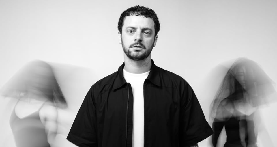 schwarz weiss Bild von einem Mann und zwei Frauen verschwommen im Hintergrund