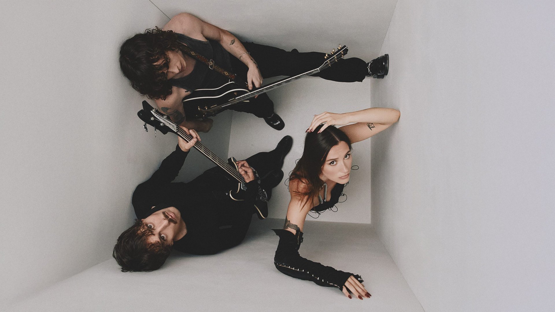 Foto für die Veranstaltung von YONAKA mit einem Bild der Band, die zu dritt in einem kleinen Raum von oben gesehen wird.