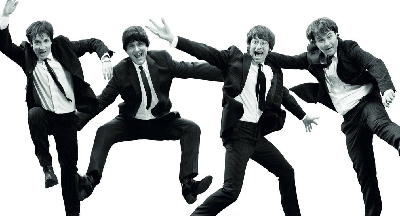 Schwarzweißfoto von vier Männern, die wie die Beatles gekleidet sind