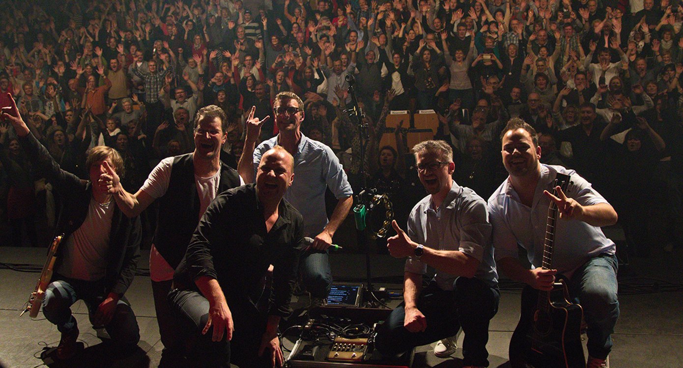 Foto der Band bei einem Konzert und des Publikums im Hintergrund