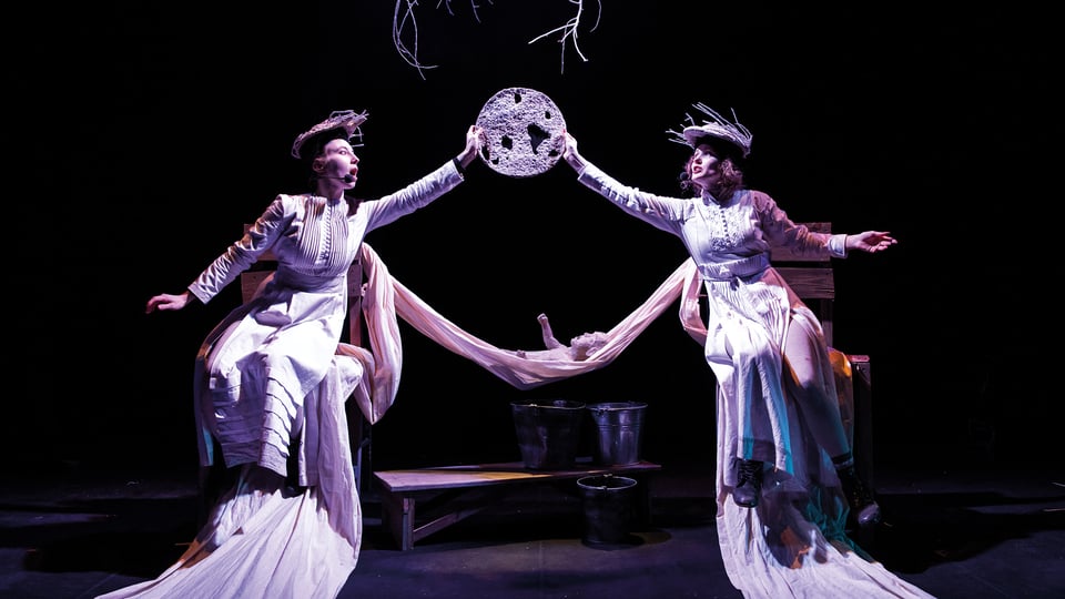 Eventfoto für „Soloway 2026 – Die Schneeballflöte“ mit einer Szene der Aufführung: zwei Darsteller:innen in weißen Kostümen.