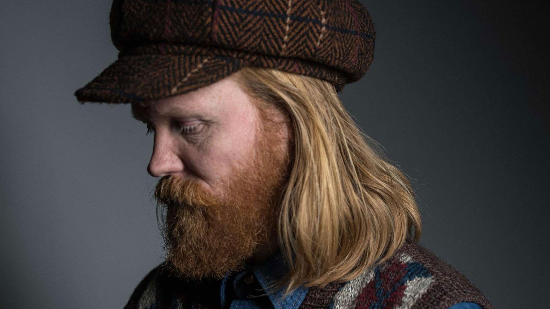 Eventfoto „Júníus Meyvant – Tour 2026“ mit dem Künstler mit Baskenmütze vor grauem Hintergrund.