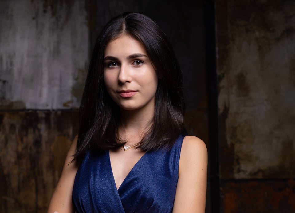 Frau in einem blauen Kleid mit dunklem Hintergrund