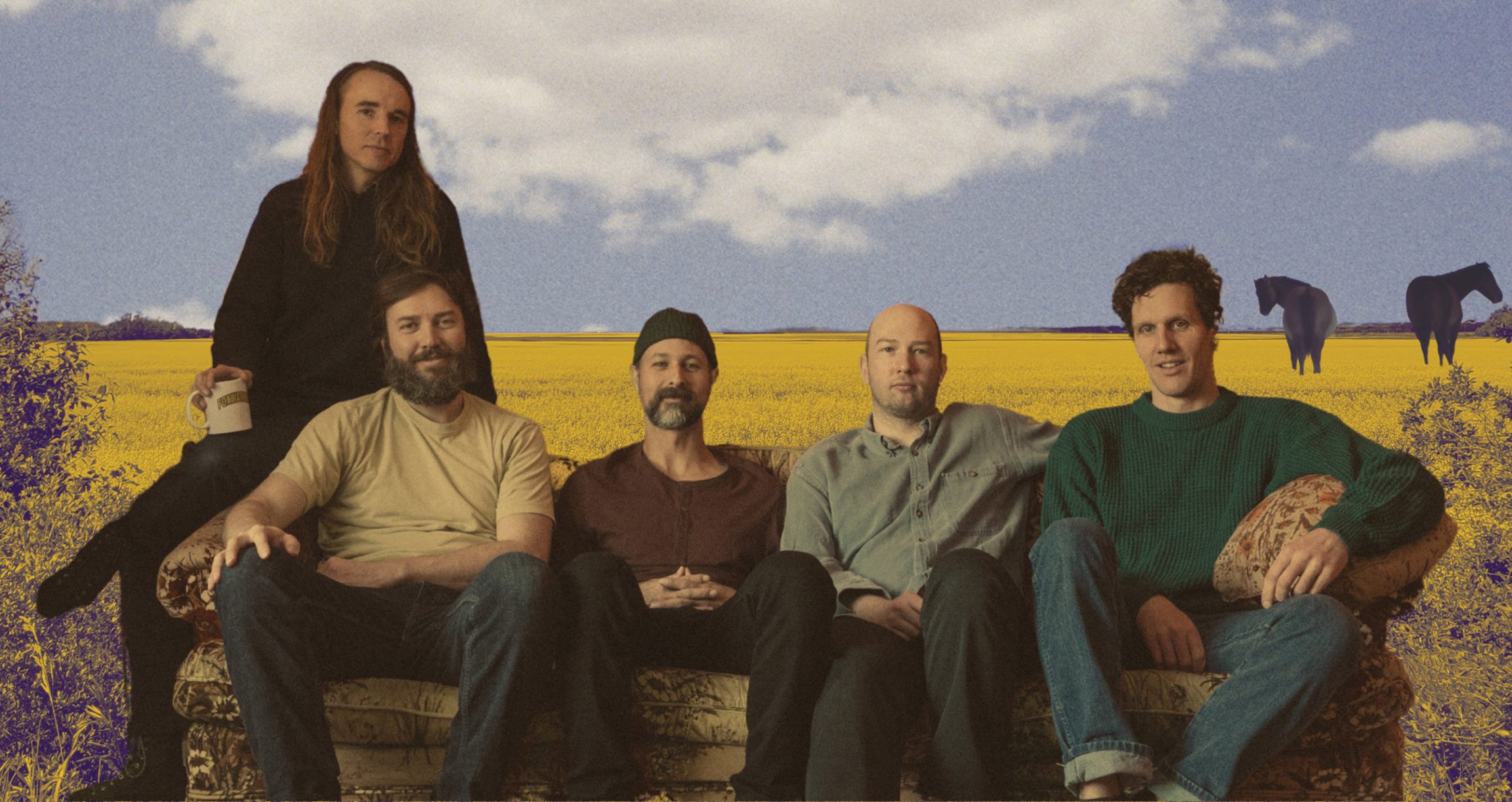 Die Band sitzt entspannt auf einem Sofa – im Hintergrund eine malerische Landschaft mit gelbem Gras, lila Blumen, zwei Pferden und einem strahlend blauen Himmel mit einer großen weißen Wolke