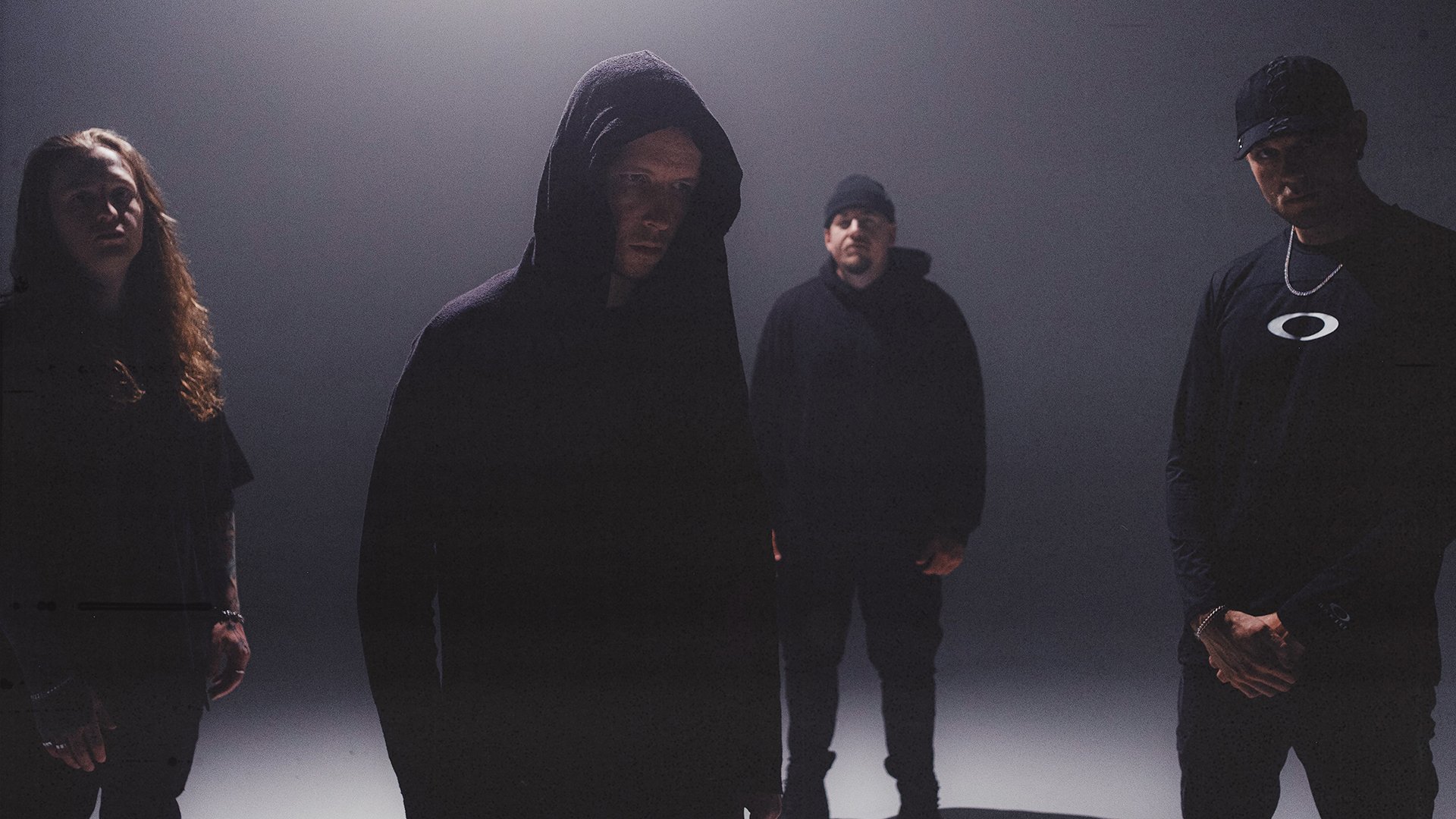 Die vier Mitglieder der Band in dunkler Kleidung mit Kapuzen und Schatten