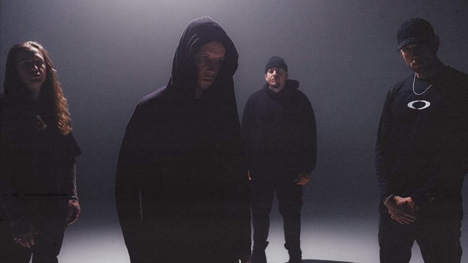 Die vier Mitglieder der Band in dunkler Kleidung mit Kapuzen und Schatten