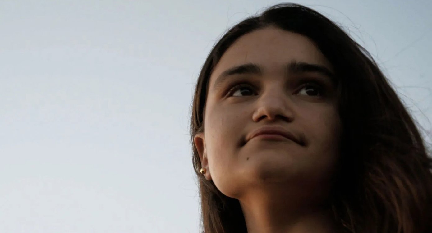 Foto des Gesichts eines Mädchens mit dem Himmel im Hintergrund