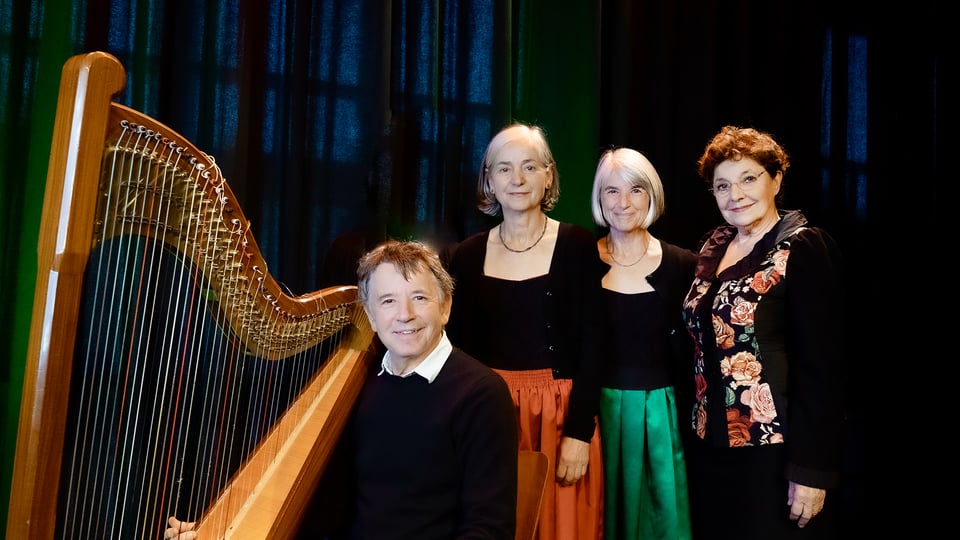Vier Musikerinnen und ein Musiker in einem Bühnenporträt mit Harfe: Ensemble Die Wellküren und Gerhard Polt vor dunklem Hintergrund, gemeinsam posierend.