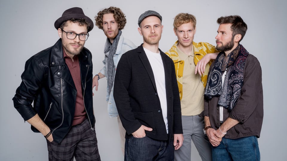 Foto für die Veranstaltung „Vokal Total – anders“, mit der Gruppe vor grauem Hintergrund.