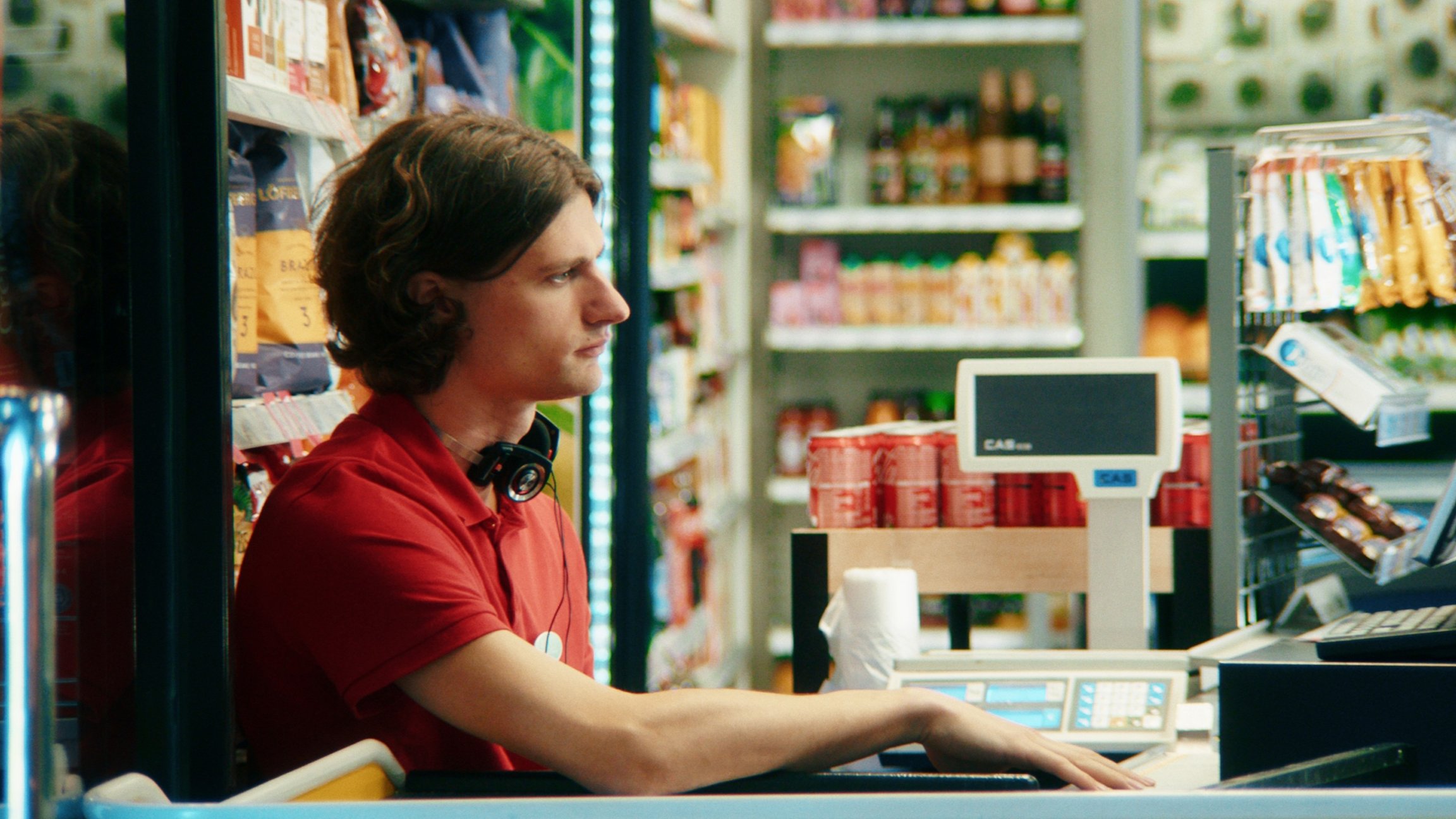 EinMann sitzt an der Kasse eines Geschäftes