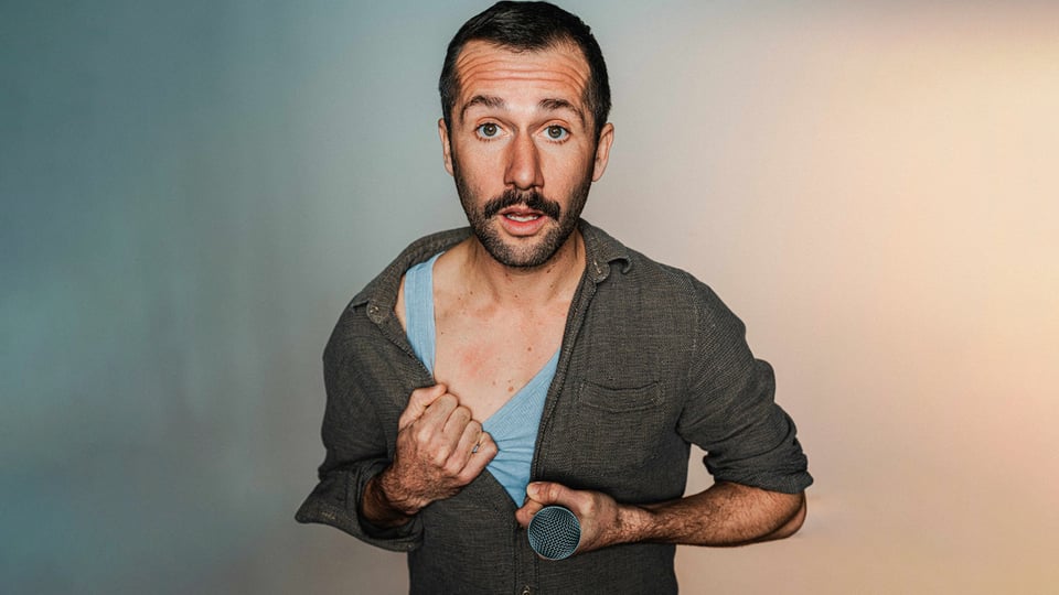 Stefan Leonhardsberger steht mit Mikro im Vordergrund