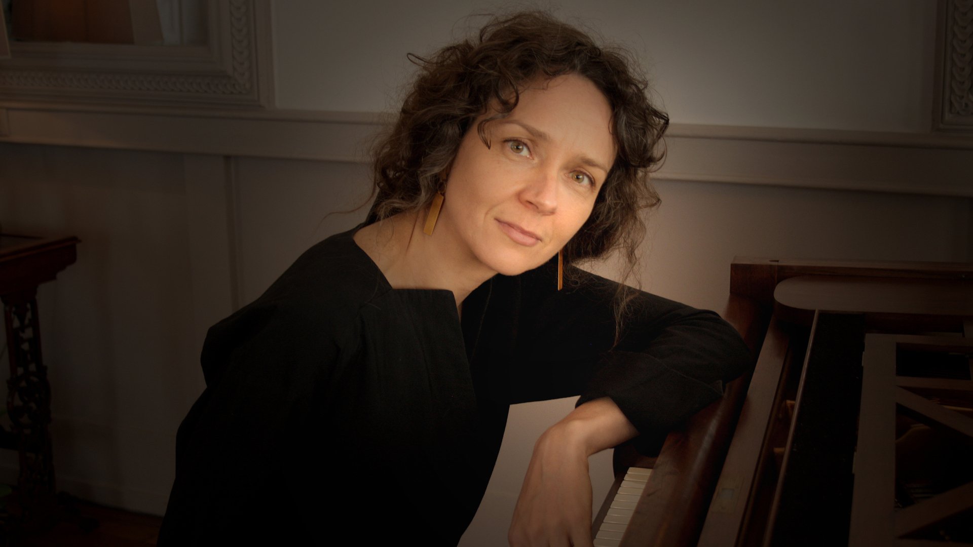 Foto für die Veranstaltung von Aglaya Zinchenko mit einem Bild der Künstlerin, die auf einem Klavier sitzt