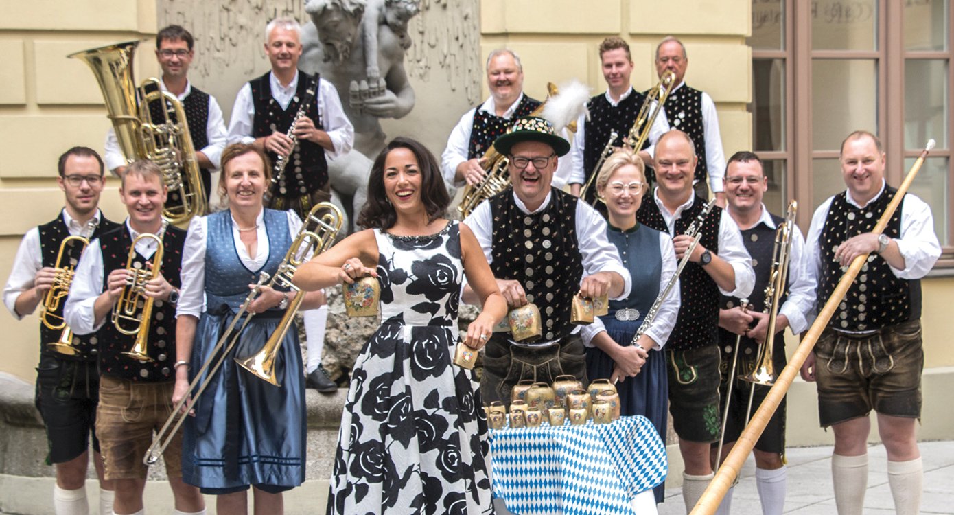 Ein Foto des Orchesters in traditionellen bayerischen Trachten mit ihren Instrumenten