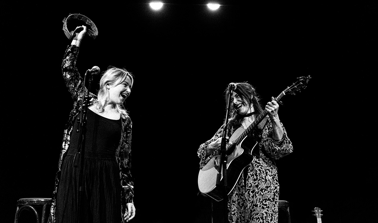 Zwei Damen in schwarz-weiss mmit Gitarre und Tamborin