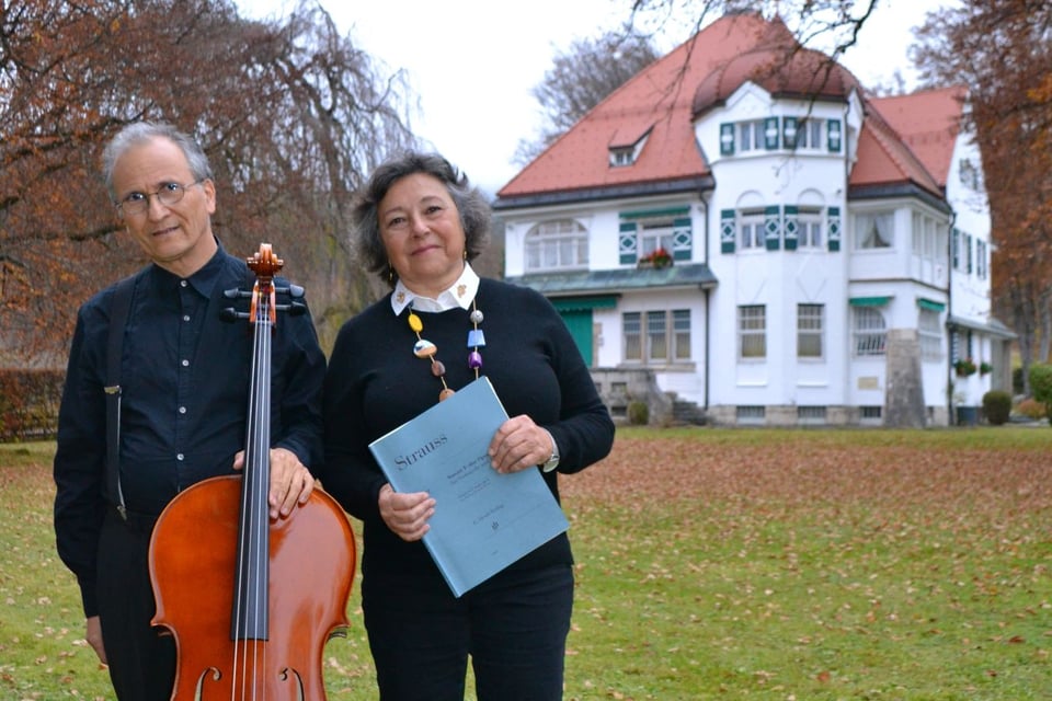 Das Arabella Duo steht mit einem Instrument auf einer Wiese, im Hintergrund eine Villa