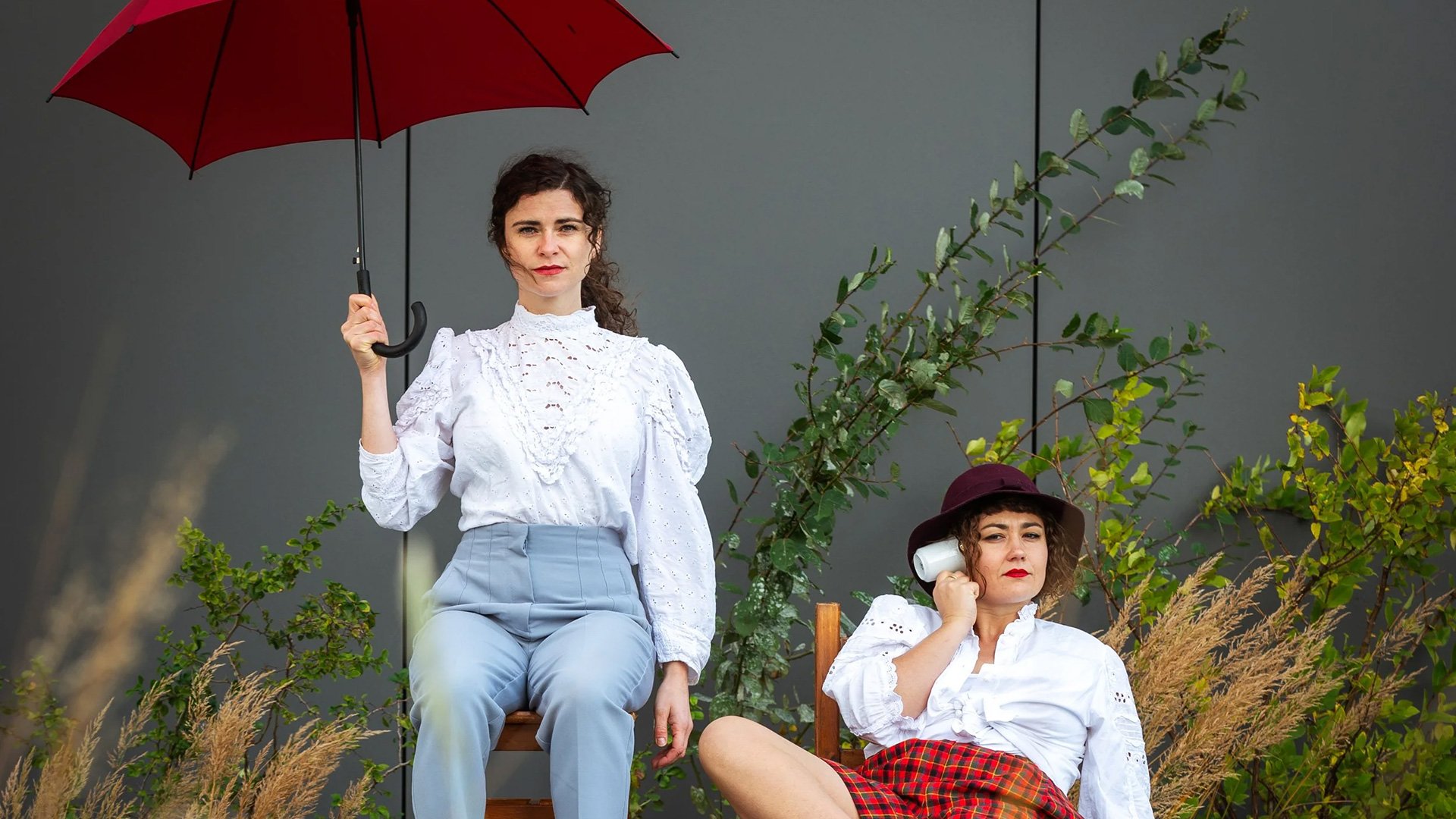 Foto für die Veranstaltung ‚Die Sache mit den Dingen‘ mit zwei Frauen und einem roten Regenschirm