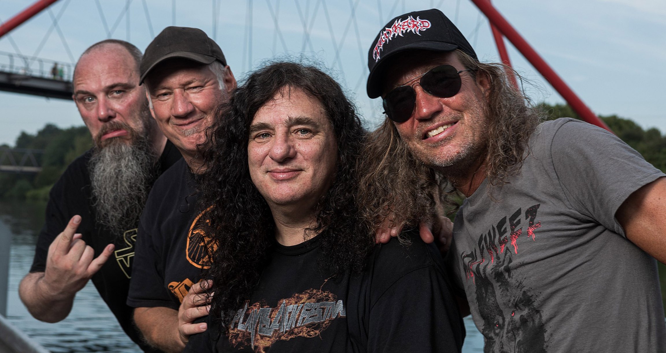 Foto der Band mit einem Fluss und einer roten Brücke im Hintergrund.