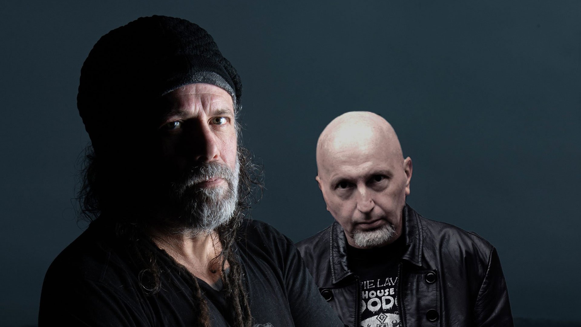 Foto für die Veranstaltung „SIX FEET UNDER“ mit zwei Künstlern vor dunklem Hintergrund.