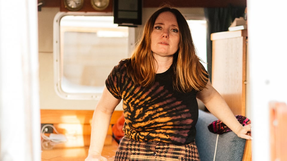 Die Künstlerin in braun gemusterter Kleidung