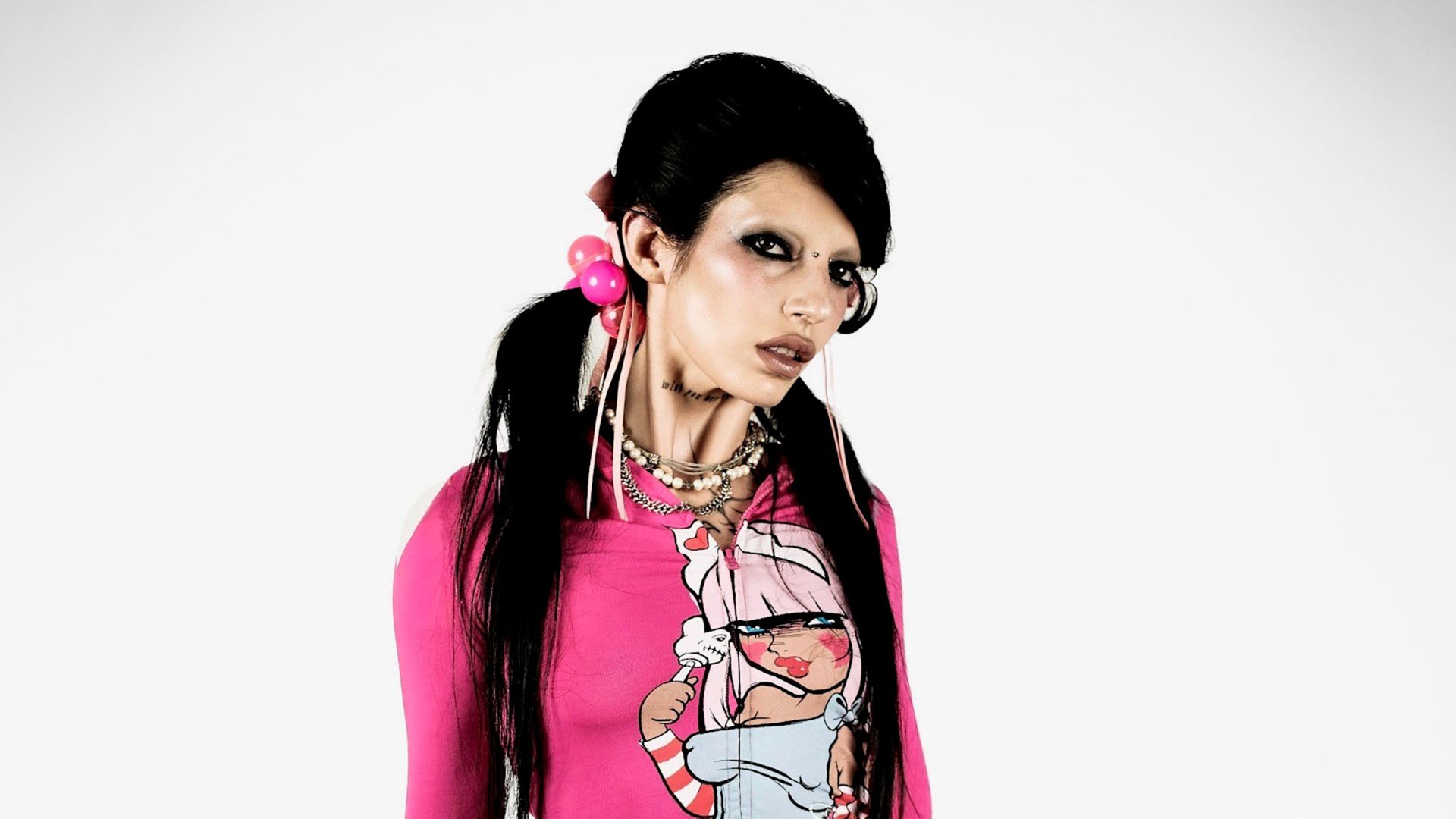 Schwarzhaarige Dame in pink-buntem Oberteil und mit pinkem Haarschmuck