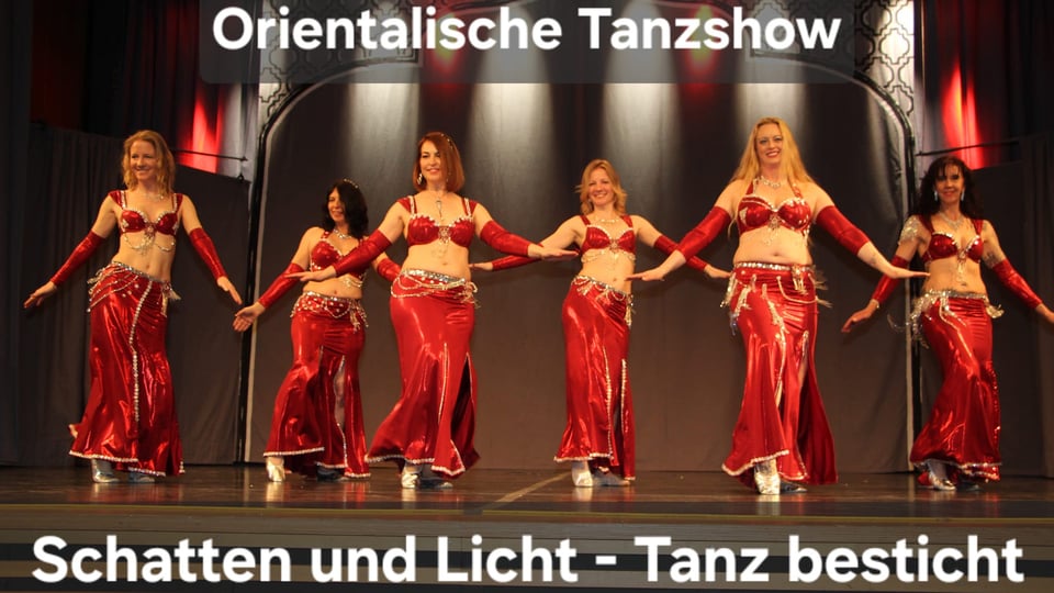 Mehrere Tänzerinnen in roten Kostümen führen eine orientalische Tanzshow auf einer Bühne auf; im Bild steht der Titel „Orientalische Tanzshow – Schatten und Licht – Tanz besticht“ – Gruppenauftritt mit synchronen Bewegungen und Bühnenbeleuchtung.