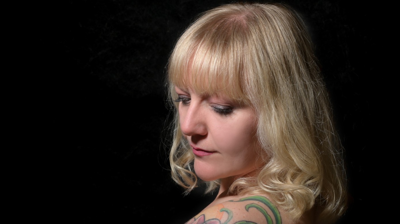 Porträt der Künstlerin vor schwarzem Hintergrund