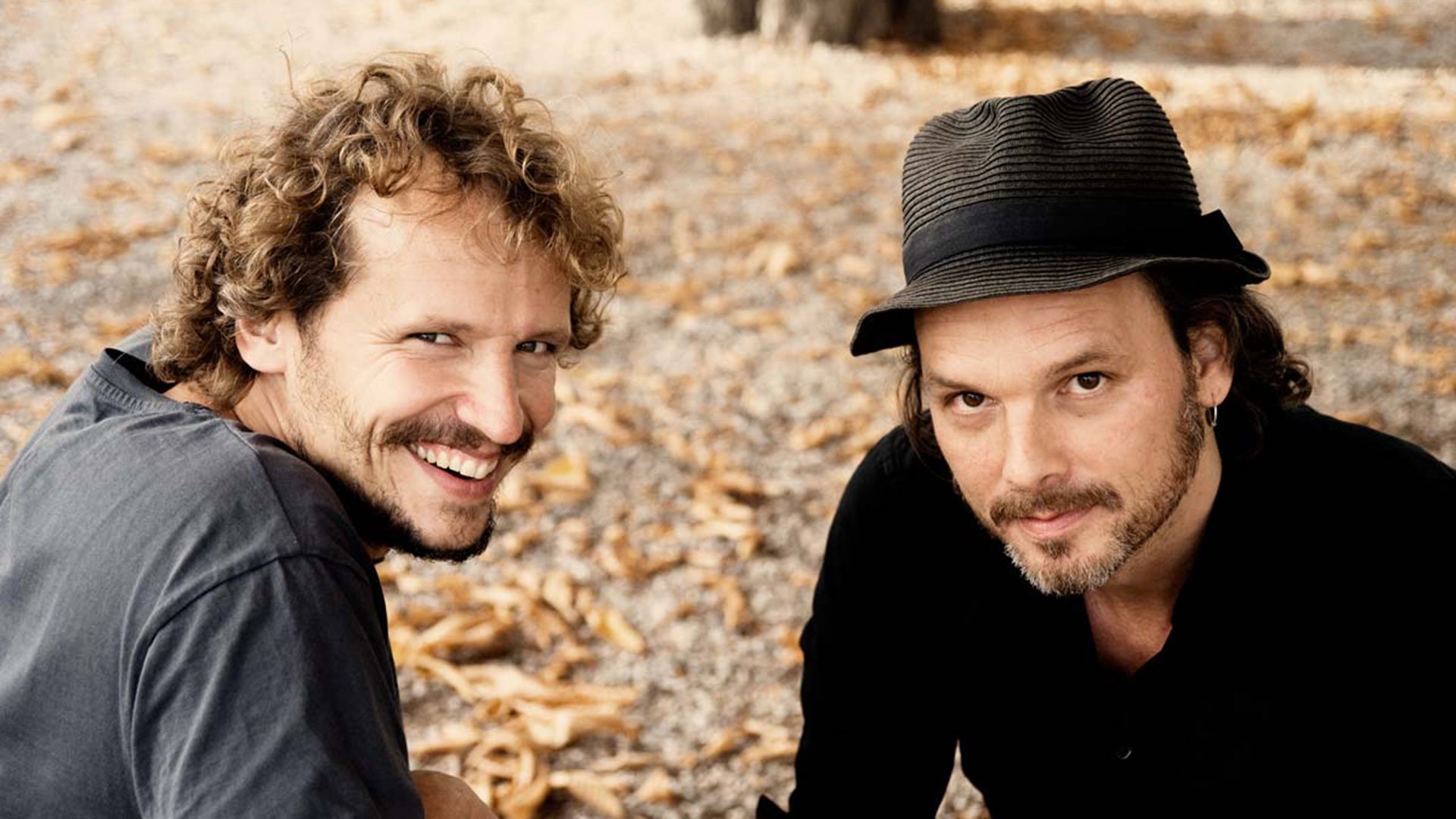 Foto für das Event Baumann & Rosenmüller mit Parade – Wenn nicht wer du – Lesung & Musik mit den beiden Künstlern und einem bodenbedeckten Laubhintergrund