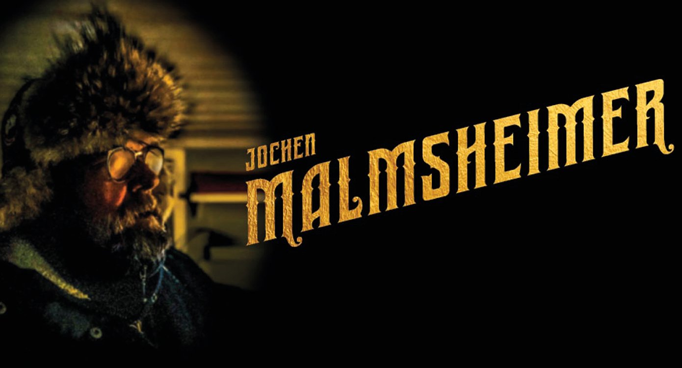 Foto des Kabarettisten Jochen Malmsheimer mit einer gelben Schrift auf dunklem Hintergrund