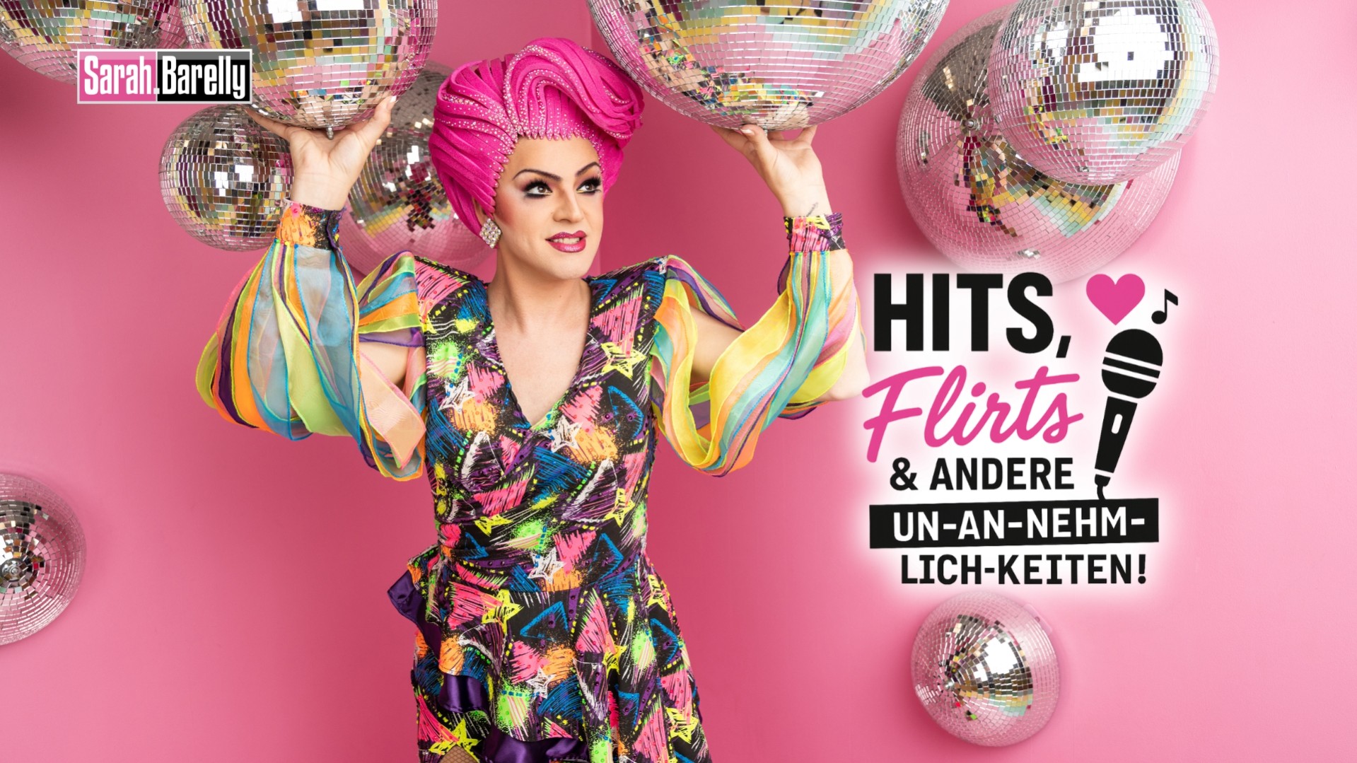 Sarah Barelly – Hits, Flirts & andere Un-an-nehm-lich-keiten: Künstlerin in buntem Outfit vor rosa Hintergrund mit Discokugeln, humorvoll inszeniert.