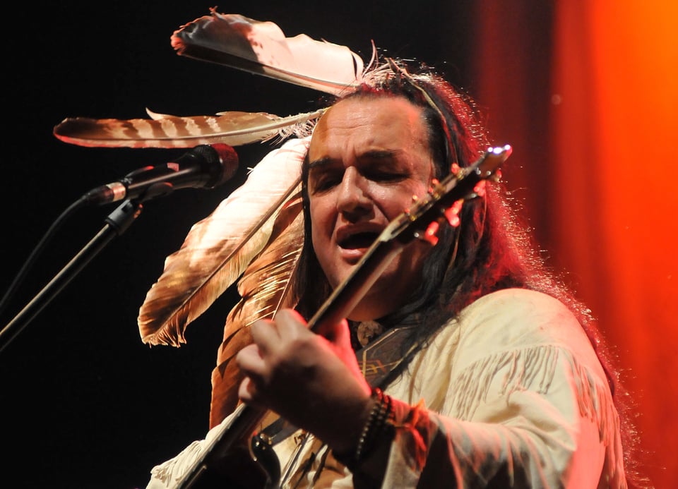 Willy Michl spielt Gitarre und singt in ein Mikrofon
