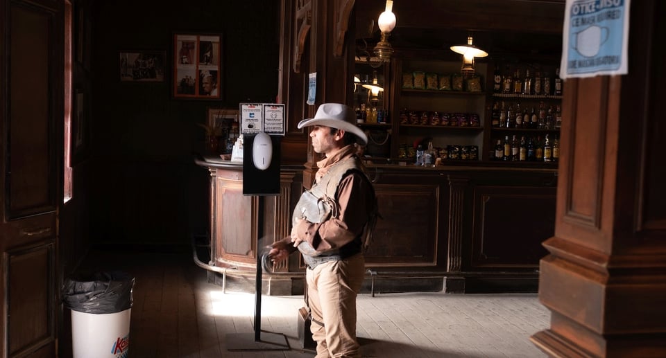 Foto von einem Mann, der als Cowboy im Cowboy-Zeit-Bar gekleidet ist.