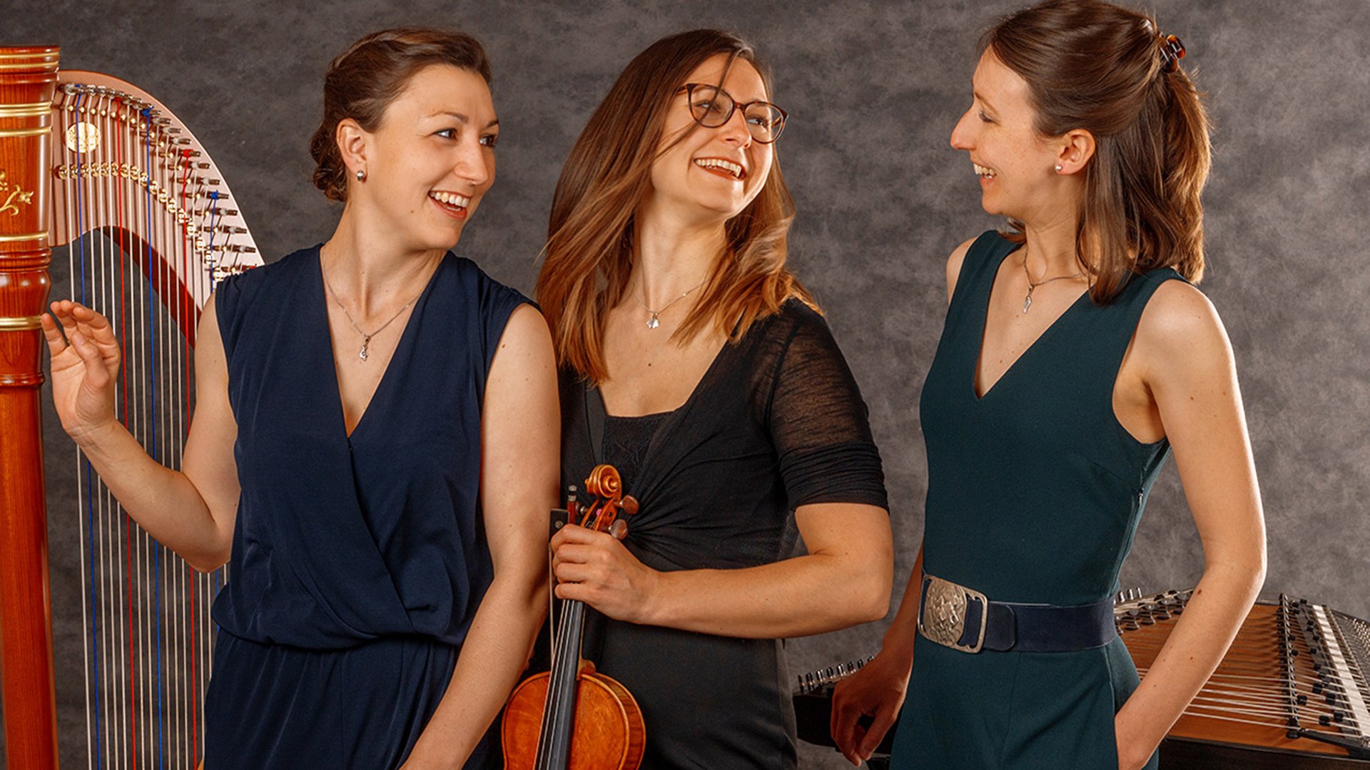 Foto für die Veranstaltung des Ensemble Vielsaitig mit den drei Künstlerinnen mit Saiteninstrumenten und einer Harfe