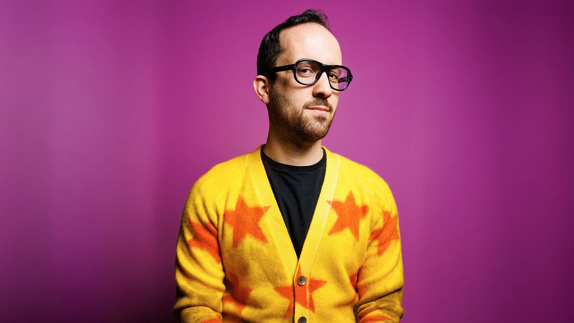 Foto für das Event Igor Levit spielt Beethoven mit dem Künstler im gelben Pullover vor lilafarbenem Hintergrund